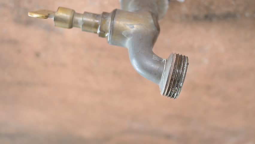 Dripping faucet, a faucet dripping continuously in slow motion, 4k, selective focus.vertical video.