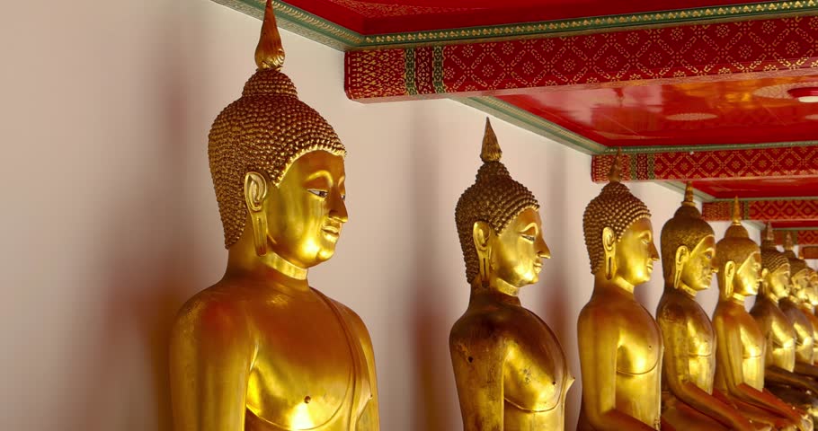 Row of Golden buddha statues inside ornate wat pho temple interior a famous conic Bangkok buddhist landmark, Thailand.