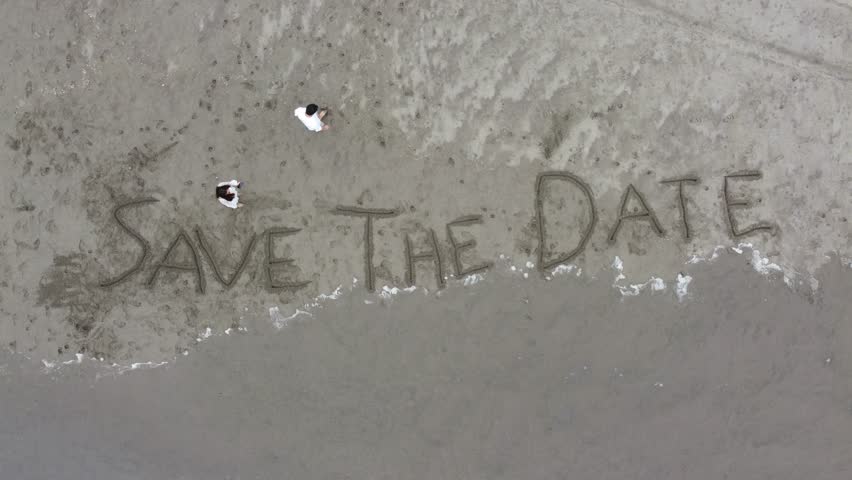 Beach wedding announcement, Romantic scene on seaside shore, Scenic aerial shot showcasing wedding celebration by ocean, Aerial view of romantic beach wedding scene with footprints and shells