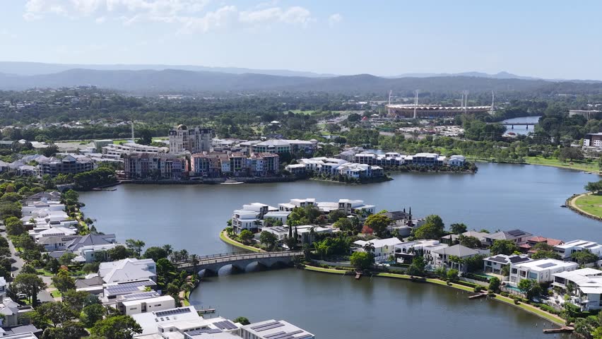 Smooth daytime drone pan across Emerald Lakes waterfront housing and surrounding suburban skyline in Australia