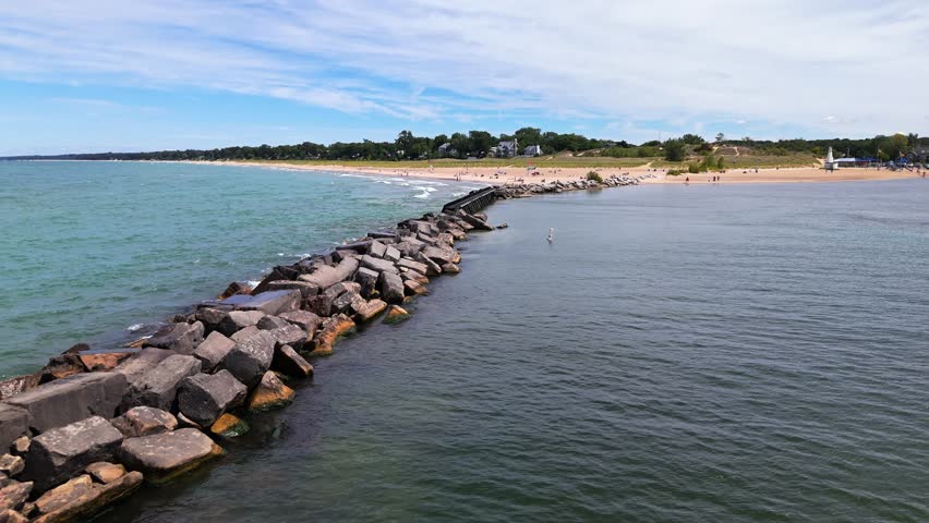 High aerial pull out shot of New Buffalo Beach, Michigan, with stunning views over Lake Michigan and the peaceful shoreline on a sunny summer day