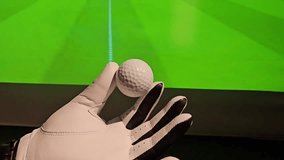 Golf ball held in hand before being putted on an indoor green in a golf simulation setup during a practice session - Powered by Shutterstock - Get 15% off with code: PIKWIZARD15