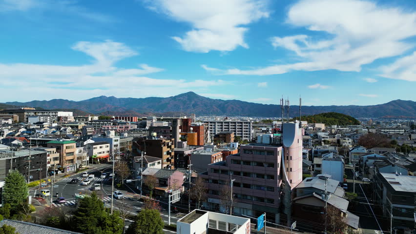 Aerial view rising over the cityscape of Kita Ward, sunny day in Kyoto, Japan