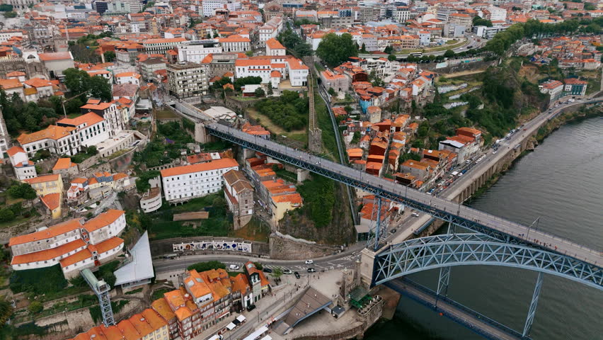 Drone shot of famous bridge Ponte de Dom Luis I in Porto city. Aerial view Porto in cloudy day with buildings on both side of Douro river