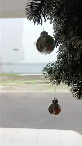 A close up view of Christmas decorations on entryway, swayning in the wind
