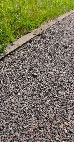 a walking path in the park made of natural finely crushed rubble, not a wide path for pedestrians to walk in the park in sunny weather