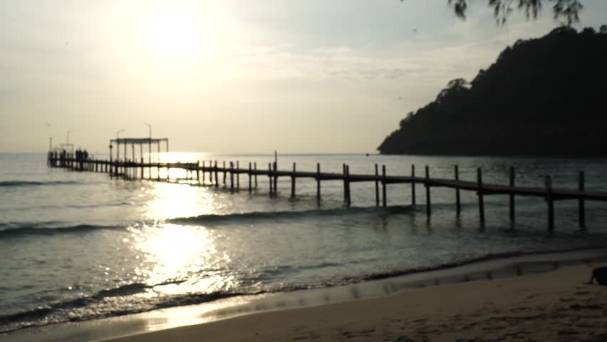 wooden bridge and resting area for tourists to watch the sunset, with mountains in the background. This landmark bridge is located on Koh Kood Island, Trat Province, Thailand.