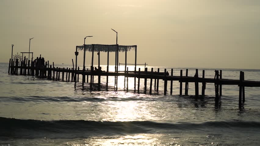 wooden bridge and resting area for tourists to watch the sunset, with mountains in the background. This landmark bridge is located on Koh Kood Island, Trat Province, Thailand.