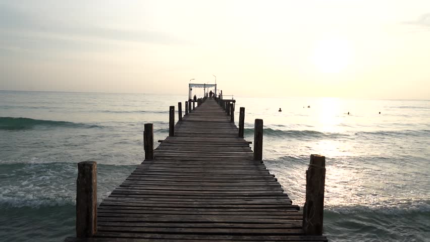 wooden bridge and resting area for tourists to watch the sunset, with mountains in the background. This landmark bridge is located on Koh Kood Island, Trat Province, Thailand.