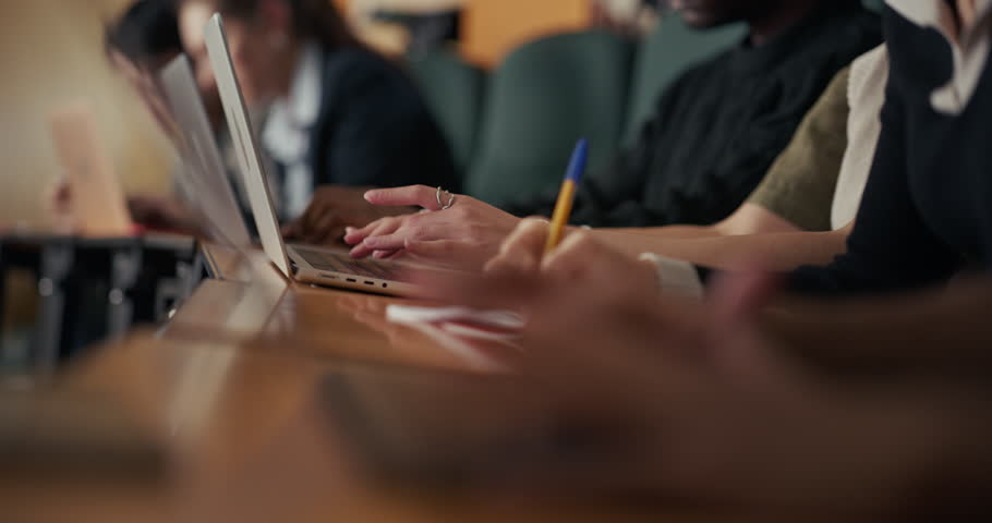 University Students Sit in a Lecture Hall Row, Typing on Laptops and Writing Notes, Concentrating on Digital Research, Academic Learning During Class Session and Organized Study. Focus Hands
