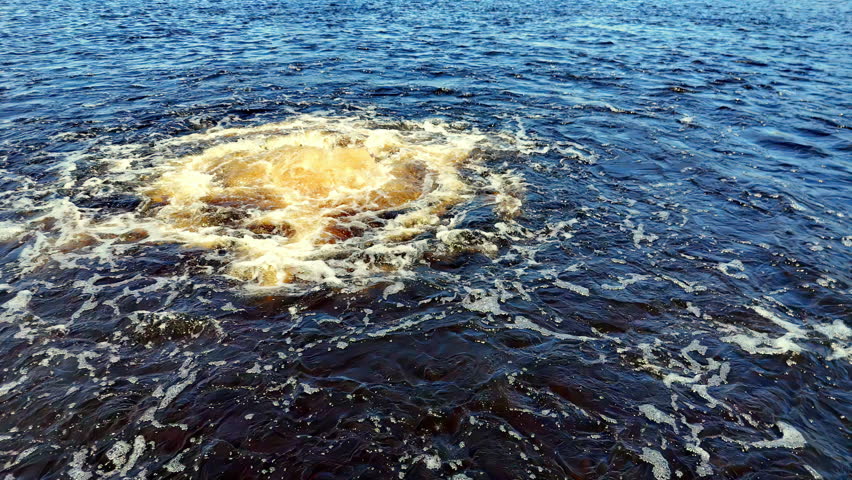 Low-angle view of a turbulent, dark-blue Baltic Sea during Autumn, with a central, massive, yellowish methane gas eruption plume
