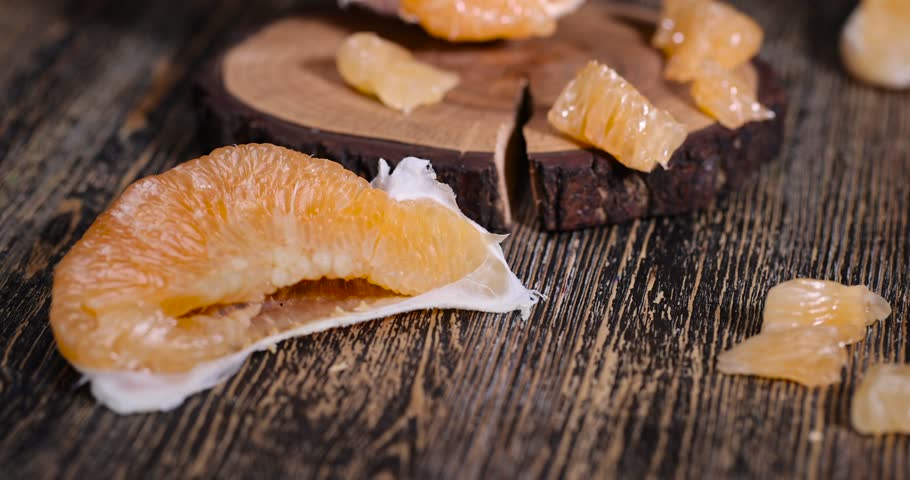 half of an orange citrus on a wooden board, ripe sweet and juicy citrus on a table made of pine wood
