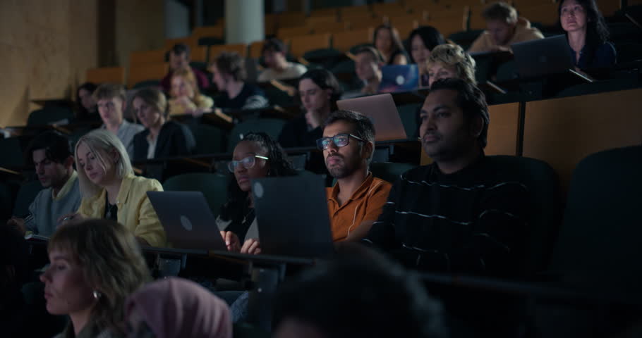 University Students Sit Lecture Hall, Typing on Laptops, Reviewing Notes and Following an Intensive Lesson, High Education, Digital Learning and Academic Preparation Fills the Classroom Environment.