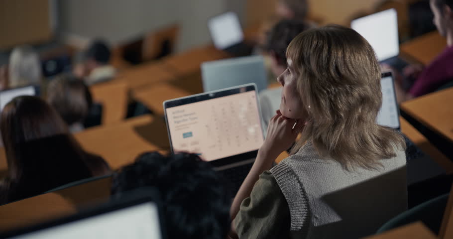 Thoughtful White Female University Student Studies Artificial Neural Network Algorithm Types on a Laptop During an Advanced Computer Science Lecture in Classroom