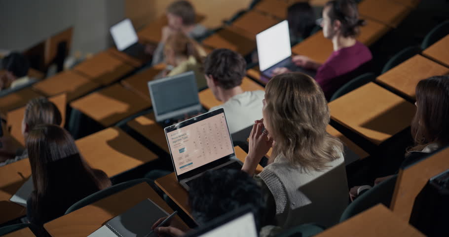 University Students Work on Laptops in Lecture Hall, Female Professor Delivers an Interactive Technology Lecture, Note Taking, Coding Practice, and Collaborative Higher Education Learning in Classroom