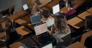 University Students Work on Laptops in Lecture Hall, Female Professor Delivers an Interactive Technology Lecture, Note Taking, Coding Practice, and Collaborative Higher Education Learning in Classroom - Powered by Shutterstock - Get 15% off with code: PIKWIZARD15