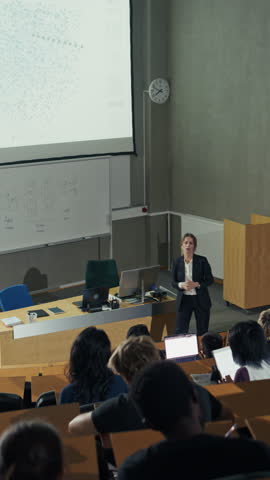 Vertical Video: White Female Data Science Professor Guiding Students Through Complex Point‑cloud Visualizations on a Large Projector as Attentive Learners Analyze Patterns, Type Notes on Laptops