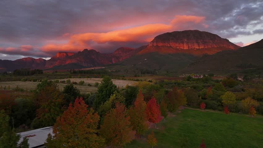 Sunset creates crimson clouds over mountains and vineyards in Stellenbosch, South Africa