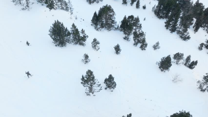 A snowboarder skiing off-piste in Grandvalira Andorra, filmed with a drone