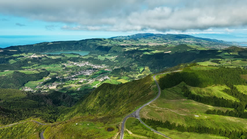 Natural landscape of Sao Miguel Island showing village and rolling hills. Azores aerial drone footage