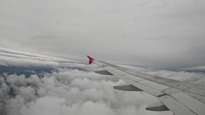 Airplane wing view over a cloudy sky during the daytime