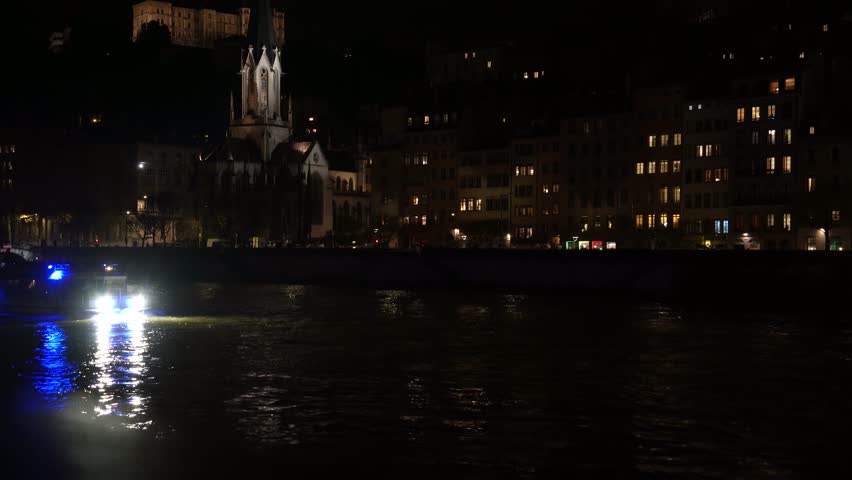 Romantic atmosphere in quiet Lyon: Illuminated buildings reflect lights on the Rhone river at night