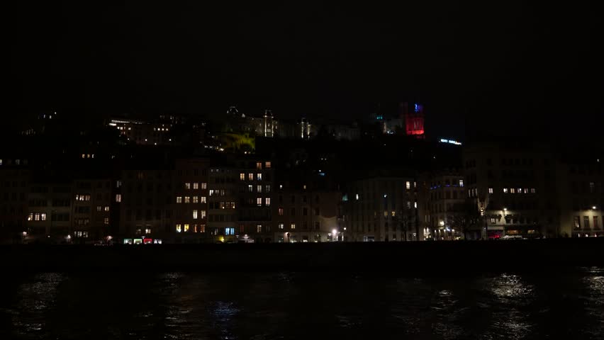 Quiet and beautiful city of Lyon on riverside with illuminated buildings at night by lights reflecting