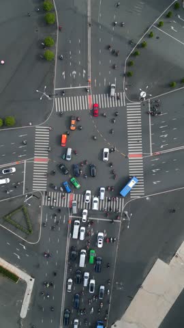Top-down drone view of busy road intersection in Ho Chi Minh City (Saigon), Vietnam. Urban traffic flow with cars, public buses, motorbikes, crosswalks, and city infrastructure in Southeast Asia.