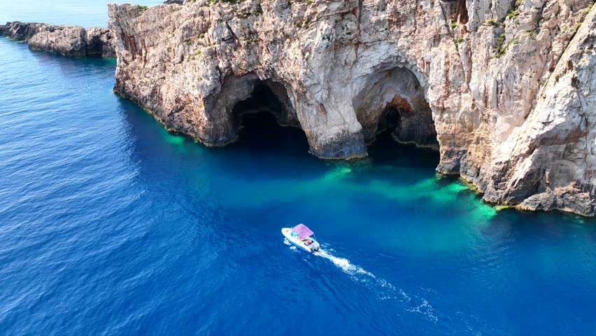Aerial drone cinematic video of tropical exotic seascape ideal for snorkeling with sea caves and white limestone rocks resembling a blue lagoon