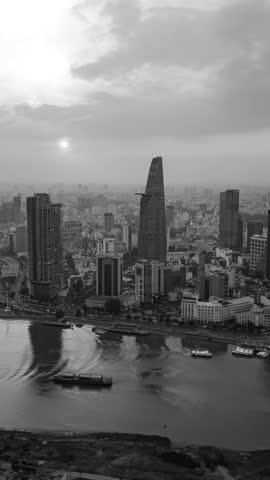 Black and white timelapse of Ho Chi Minh City skyline with river, skyscrapers, and urban traffic at sunset. Cinematic grayscale cityscape showing modern Asian metropolis and city life.
