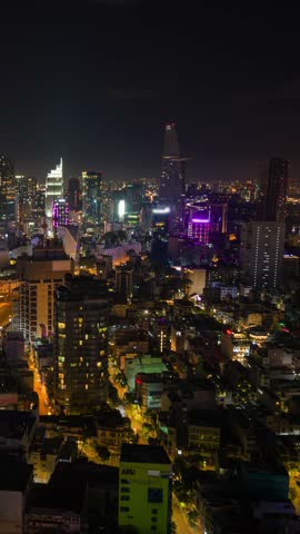 Aerial night timelapse of Ho Chi Minh City skyline with illuminated skyscrapers, vibrant lights, and moving traffic. Modern urban landscape and dynamic nightlife in Vietnam