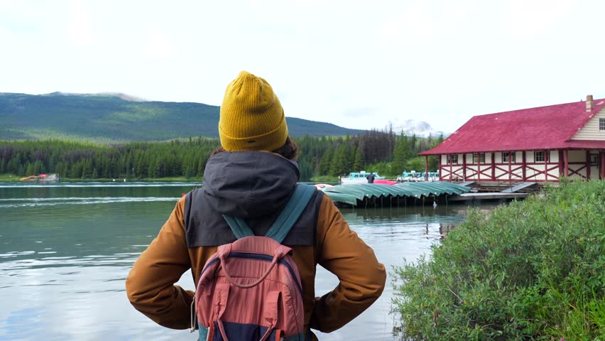 Majestic maligne lake, nestled in the heart of jasper national park, captivates a tourist with its pristine beauty and the iconic boathouse