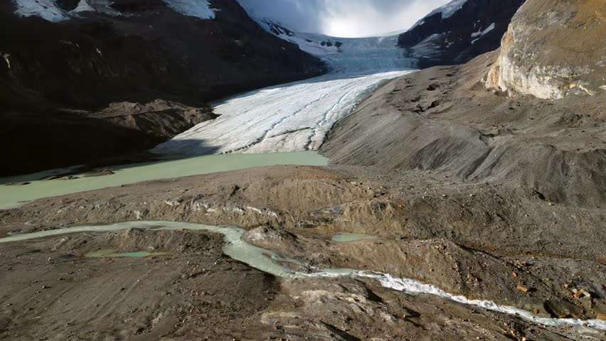 Athabasca glacier, located in the columbia icefield within jasper national park, showcases the effects of climate change with visible glacial melt and receding ice formations
