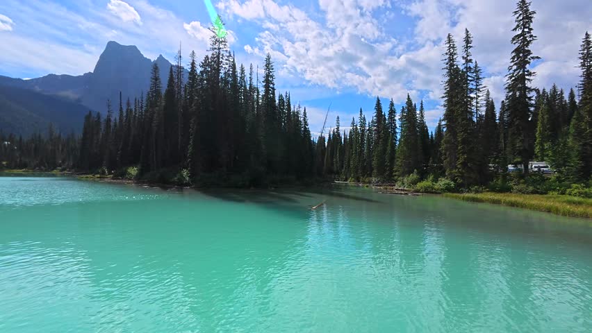 Turquoise water of emerald lake reflects the surrounding canadian rockies and a wooden lakeside building in banff national park, british columbia, canada