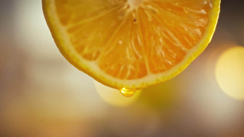 Close-up, freshly cut lemon reveals intricate fibers seeds, with single drop of juice trickling down, capturing the texture granularity of the pulp in vivid detail on simple, elegant background