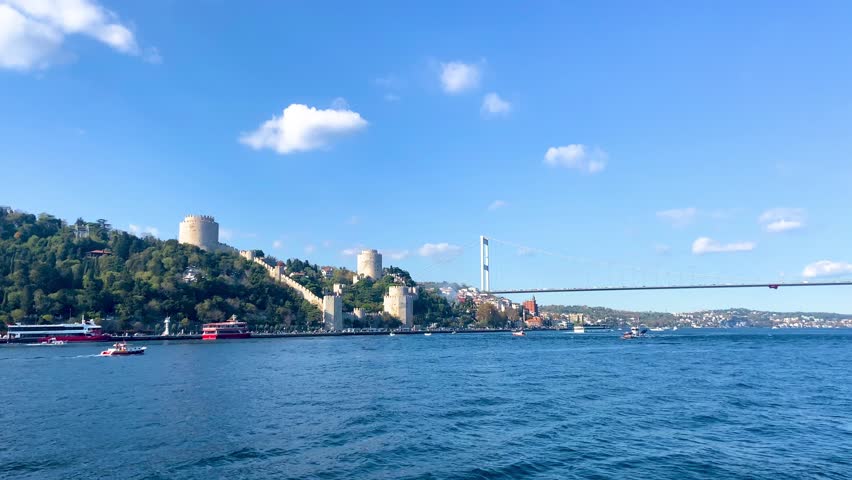 Cinematic slow motion view of Fatih Sultan Mehmet Bridge and historical Rumeli Fortress with flying seagulls seen from Bosphorus ferry in Istanbul