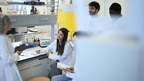 Senior female professor explaining scientific concepts to a diverse group of university students during a practical lesson in a laboratory - Powered by Shutterstock - Get 15% off with code: PIKWIZARD15