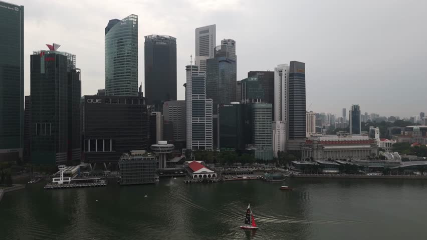 Aerial view of Singapore’s central business district along the river, featuring modern skyscrapers, waterfront buildings, and the dense urban skyline of a leading global financial hub.