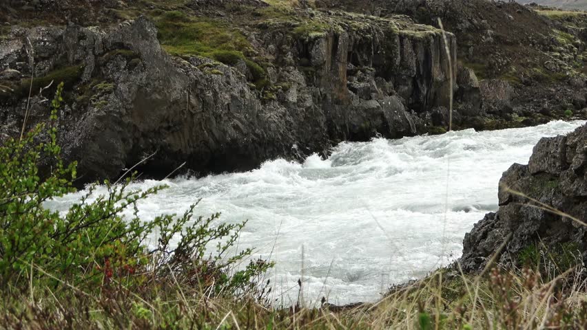 Rushing white water rapids flowing through a rocky gorge in the Icelandic highlands