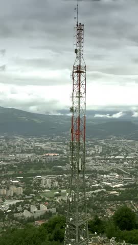 FPV drone aerial shot of the modern 5G telecommunication tower close to Grenoble, France, vertical video
