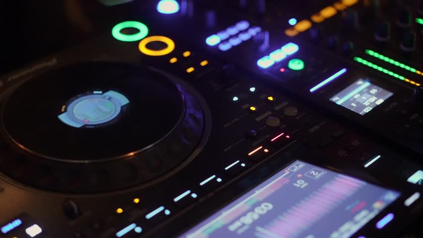 Closeup Illuminated DJ Controller With Lights And Platter, Colorful Buttons And LCD Display, Fingertips Adjusting Tempo And Crossfader,