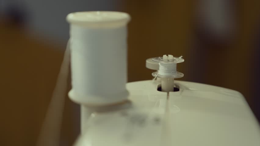 The bobbin is threaded with white thread on the sewing machine.
