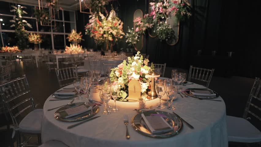 Elegant wedding reception table setup with floral centerpiece and glassware.