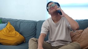 Smiling young man with Down syndrome chats happily on his smartphone while relaxing at home on couch - Powered by Shutterstock - Get 15% off with code: PIKWIZARD15