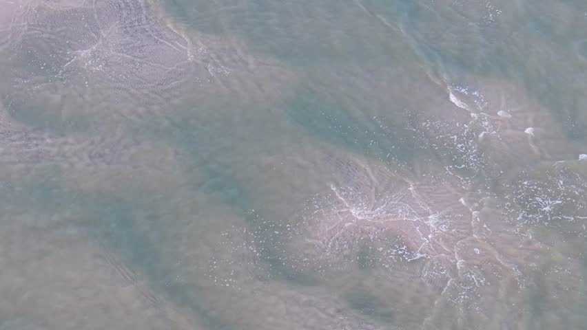 Aerial top-down view of swirling water currents with foam patterns on the surface in Charleston, South Carolina.