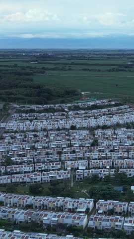 Discover a panoramic aerial vista of Valle del Cauca's residential area. The vertical video captures neatly arranged homes against lush landscapes. Ideal for social media stories.