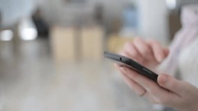 Close-up of a woman swiping on a mobile phone in a daytime office, modern work lifestyle, touchscreen technology, online communication, business concept. - Powered by Shutterstock - Get 15% off with code: PIKWIZARD15