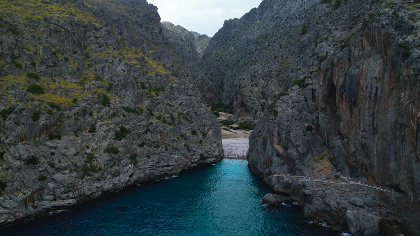 The dual beauty of Sa Calobra in Mallorca. The extreme serpentine road and the dramatic Torrent de Pareis gorge where it meets the sea, both set within the Serra de Tramuntana mountains.