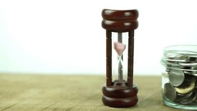 Sand dropping through the bulb of the hourglass and money on the background. Hourglass with sand stand among money. Deadline, business planning, finance and time is money concept. - Powered by Shutterstock - Get 15% off with code: PIKWIZARD15