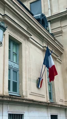 Waving national flags of France and the shield with letters RF Republique Francaise or French Republic on the typical administrative building, vertical video